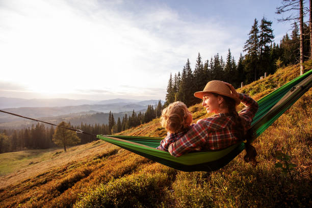 istock Boy with mom resting in a hammock in the mountains at sunset 1346029803