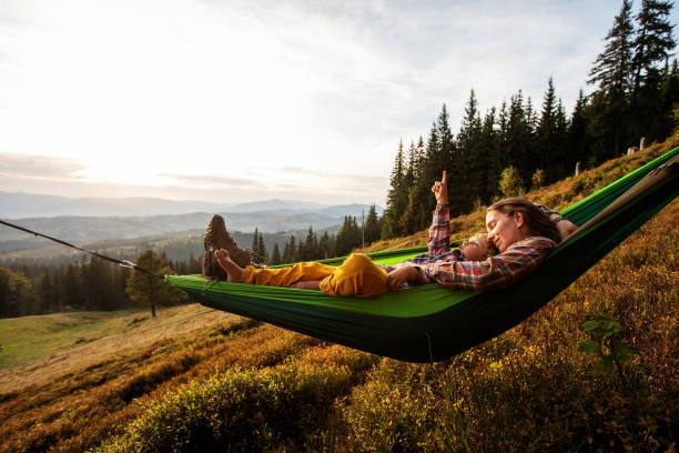 istock Boy with mom resting in a hammock in the mountains at sunset 1346029809