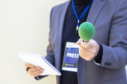 Reporter holding microphone making media interview