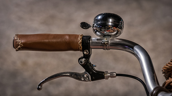 Old bike handlebar with bell and lamp.