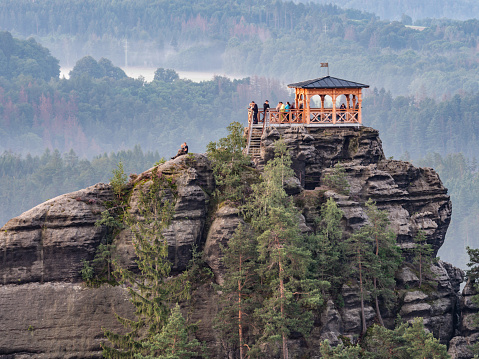 Breakfast or morning picnic of tourists group on popular lookout tower Mariina vyhlidka. The significant viewpoint in Bohemian Switzerland National Park, Czech Republic.