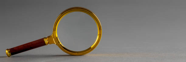 istock a golden magnifier on black paper background 1346037595