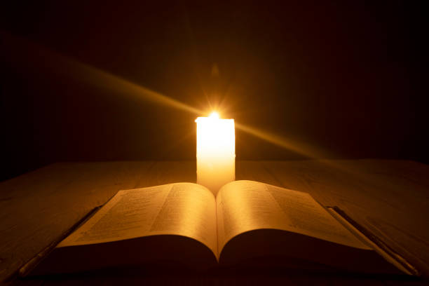 istock bible on the table in the light of a candle 1346037616