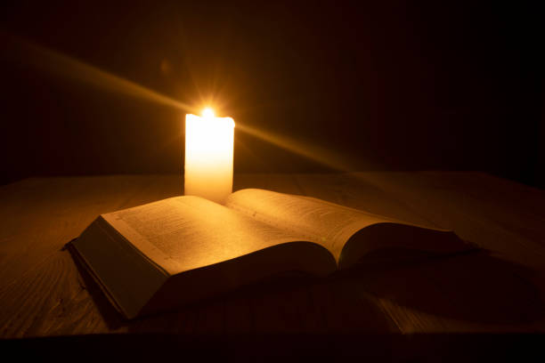 istock bible on the table in the light of a candle 1346037621