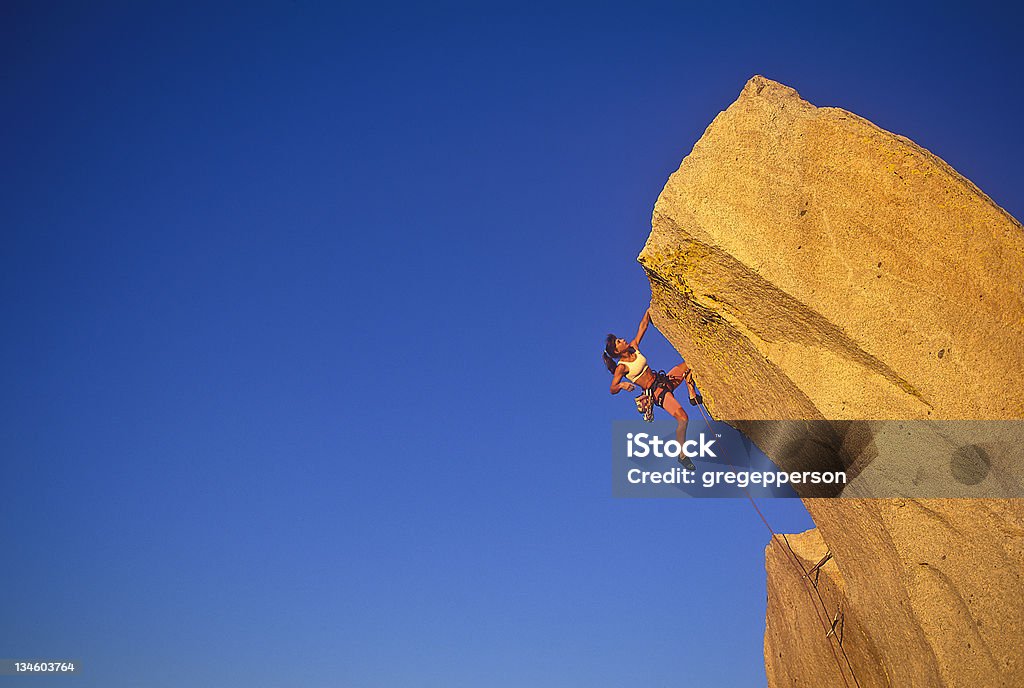 Kobieta wspinacz clinging na krawędź. - Zbiór zdjęć royalty-free (Wspinaczka skalna)