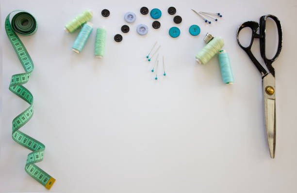 istock Background with sewing accessories. Scissors, tape measure, pins, threads, buttons on a white background. Sewing accessories. 1346039496