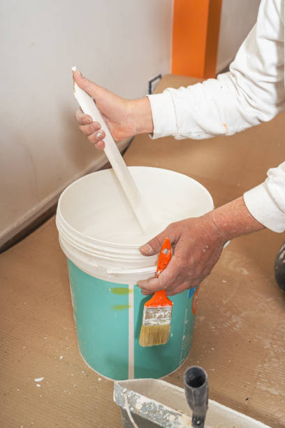 istock Young man mixing the paint in the bucket. 1346039789