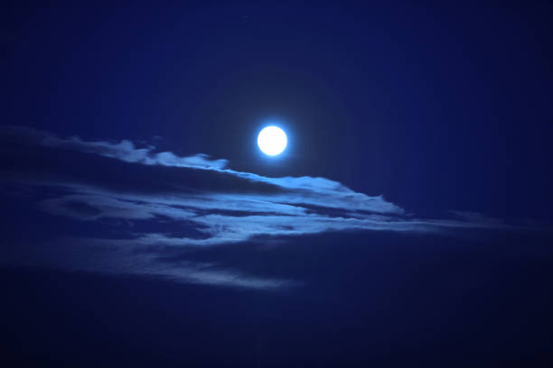 istock A beautiful big moon in a dark blue sky with clouds. 1346043875