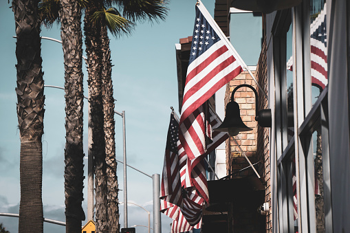 American flags and palm trees in Huntington Beach California