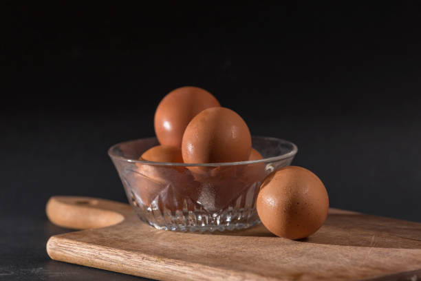 istock raw eggs hanging in a bowl on black background 1346047486