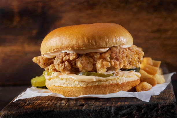 スパイシーなクリスピーフライドチキンバーガー、フライドポテト添え - chicken sandwich ストックフォトと画像