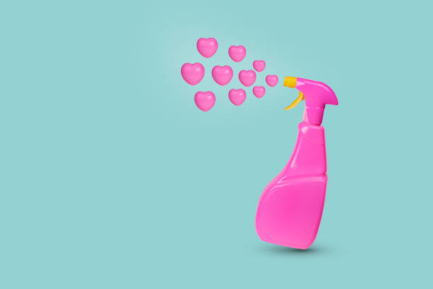 Creative Valentine's or romantic concept with dispenser bottle spraying pink hearts on a pastel blue background. Minimal love background.