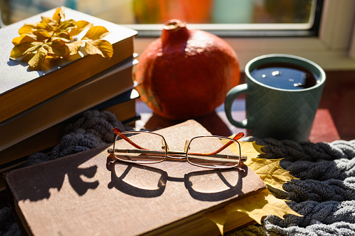Autumn composition on the theme of autumn and home reading. Selective focus on reading glasses.