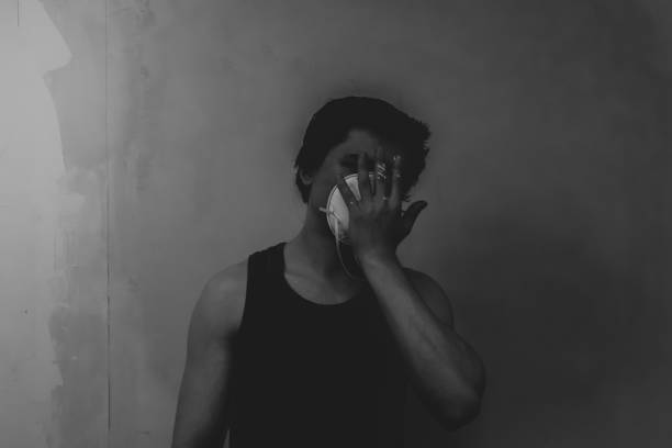 istock Man in mask doing paint works. spots of paint on the hand 1346058741