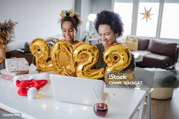 Mother And Daughter Celebrating Online 2022 Year And Holding Balloons Stock Photo - Download Image Now