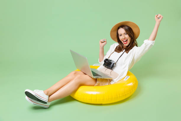 Full lenth traveler happy tourist woman in casual clothes hat sit in inflatable swimming ring use laptop computer winner gesture isolated on green background Travel abroad weekend Airflight concept Full size body traveler happy tourist woman in casual clothes hat sit in inflatable swim ring use laptop pc computer winner gesture isolated on green background Travel abroad weekend Airflight concept holiday sale stock pictures, royalty-free photos & images