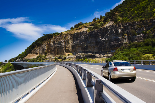 passenger sedan car moving on sea cliff bridge in Australia - highway road in summer sunny day