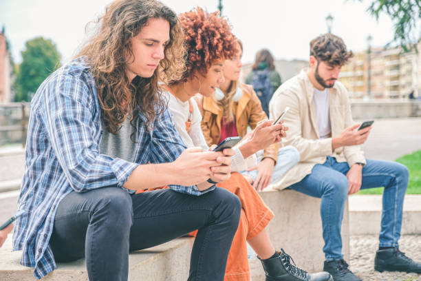 istock Multicultural group of friends using mobile phones - Students sitting in a row and typing on smartphones 1346070831
