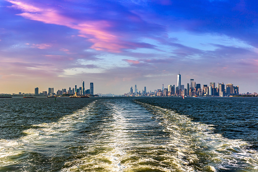 Cruise wash foam in Hudson river and Panoramic view of Statue of Liberty and Manhattan and Jersey city  in New York City, NY, USA