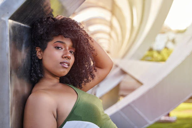 portrait of young latina touching her curly hair. fashion and beauty concept. portrait of young latina touching her curly hair. fashion and beauty concept. septum piercing stock pictures, royalty-free photos & images