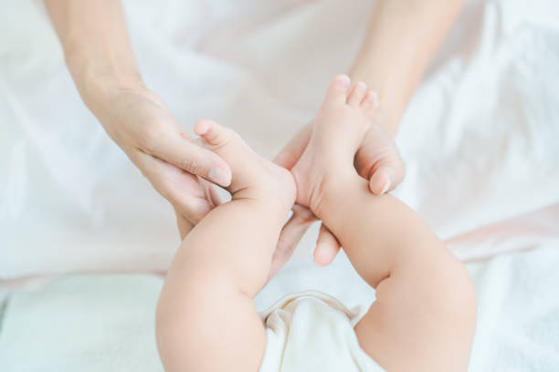 istock Mother's hands supporting the baby's feet 1346071654