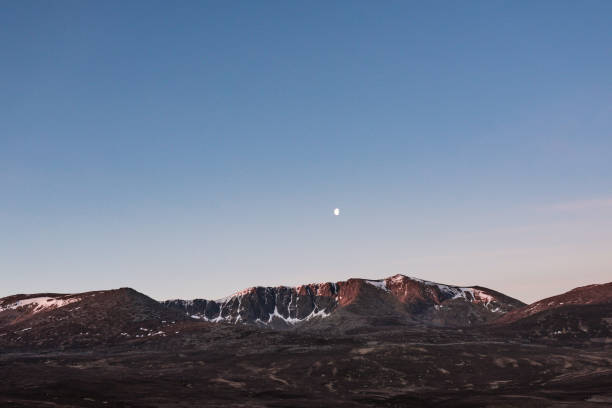 Cairngorm Snow Mountain Range at Dawn with Moon stock photo