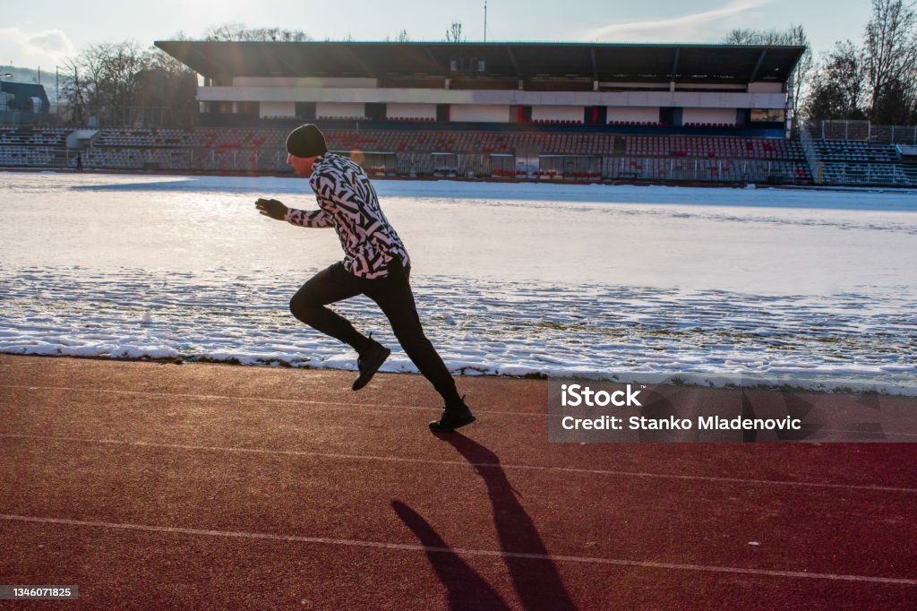 athlete running, sprinting An athlete running on a running trail on sport field 25-29 Years Stock Photo