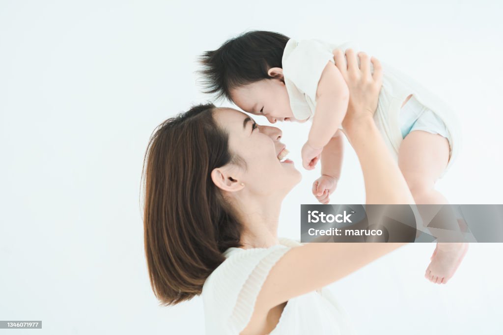 Mom holding the baby high Mom holding the baby high in the bright room Baby - Human Age Stock Photo