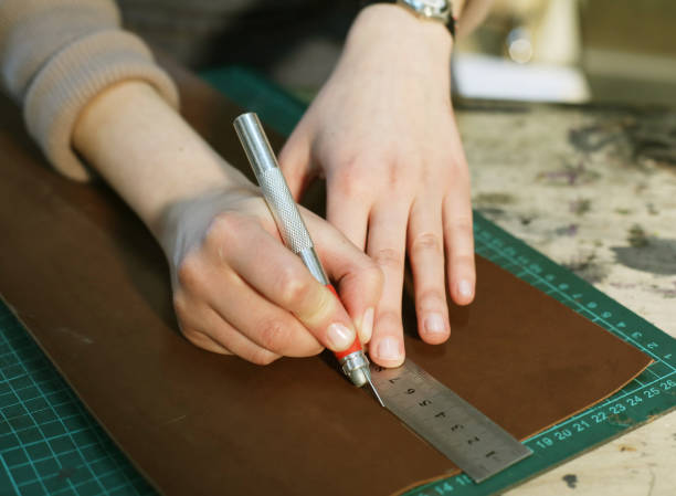 istock woman works in a bag making studio, cuts out details 1346072911