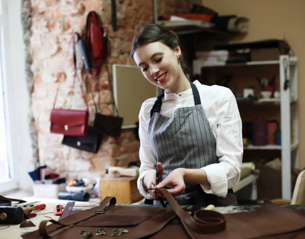 istock woman works in a bag making studio, cuts out details 1346072913