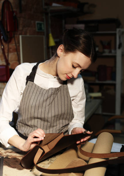 istock woman works in a bag making studio, cuts out details 1346072925