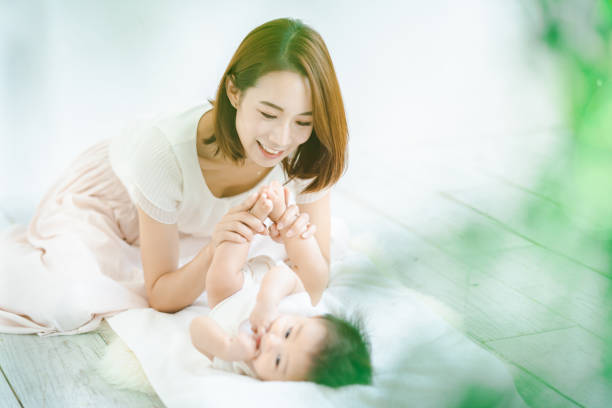 Asian mom and baby playing indoors