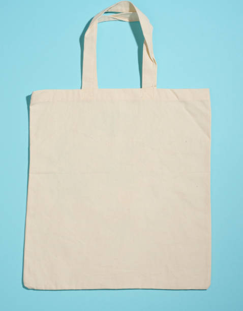 istock empty linen eco friendly beige canvas tote bag for branding on blue background. Clear reusable bag for groceries, mock up 1346074747