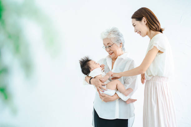 赤ちゃんと女性を抱きしめるシニア女性 - two generation family 写真 ストックフォトと画像