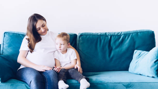 istock Cute small boy talking with his pregnant mother 1346080517