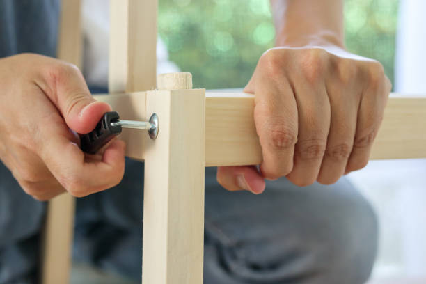 assemblaggio di mobili in legno a casa usando la brugola a vite - screwdriver screw tighten fastener foto e immagini stock