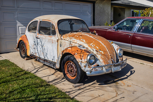 Oxnard, United States - February 20 2020 : old vintage cars are parked on the driveway in front of a home in an american suburb