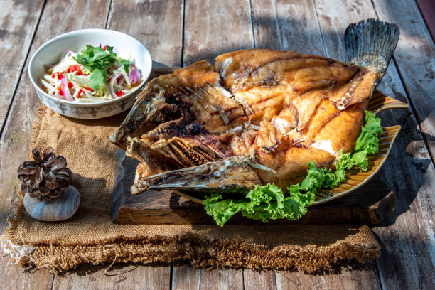 istock Deep fried Snapper with fish sauce on vintage wooden. 1346081231