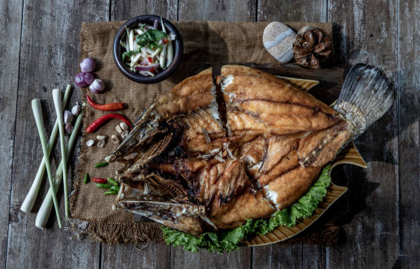istock Deep fried Snapper with fish sauce on vintage wooden. 1346081241