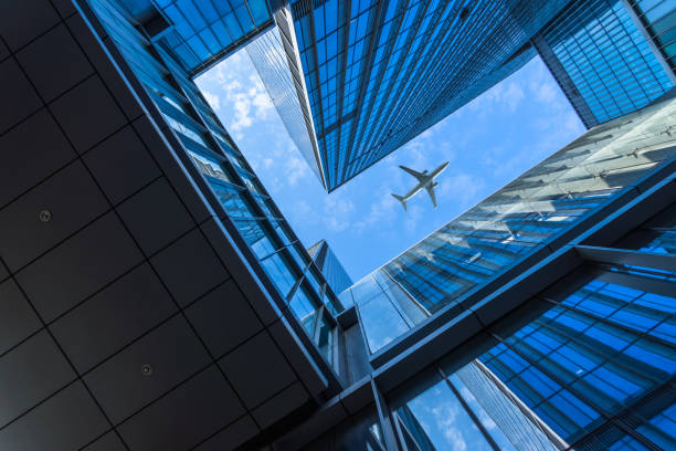 Plane flying over the skyscrapers Air Vehicle, Airplane, City, Cityscape, Commercial Airplane aerospace industry stock pictures, royalty-free photos & images