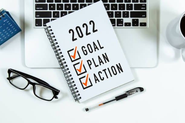 2022 цель, план, действие контрольный список текста на блокноте с ноутбуком, очками и ручкой. - ворота стоковые фото и изображения
