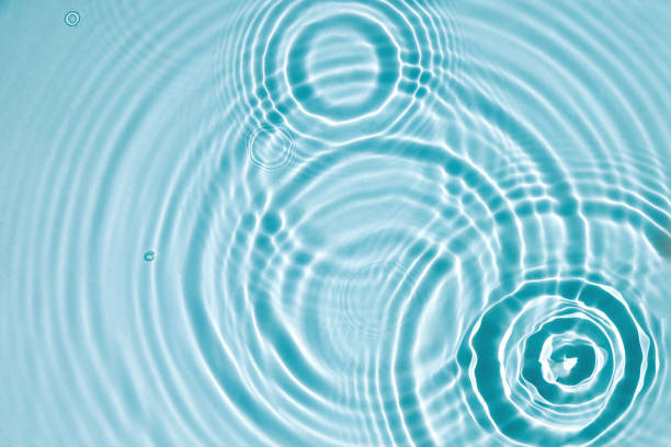 Water background. Blue water texture, blue mint water surface with rings and ripples. Spa concept background. Flat lay, top view, copy space.