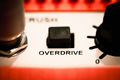 Close up of a guitar amplifier. The focus of the image is a button that simply says OVERDRIVE.