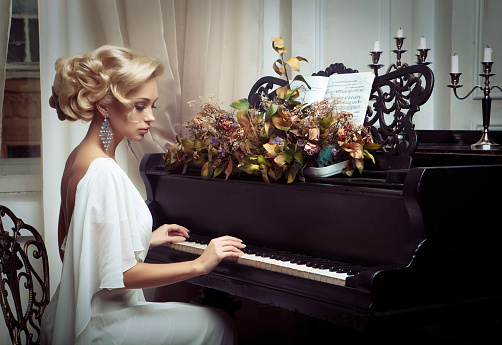 Beautiful young bride playing the piano. Happy wedding.