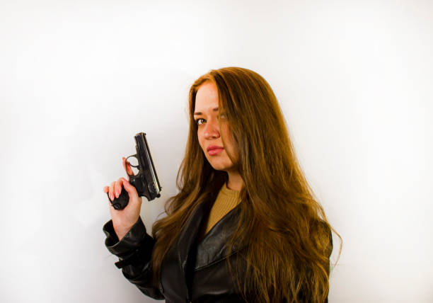 istock young beautiful woman with a gun 1346101954