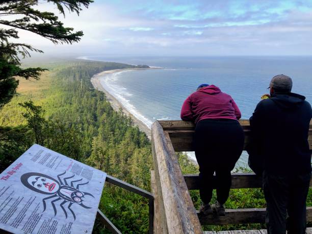 A couple admiring the coastline and  beaches of north beach, atop the tow hill viewpoint, in Haida Gwaii, British Columbia, Canada stock photo