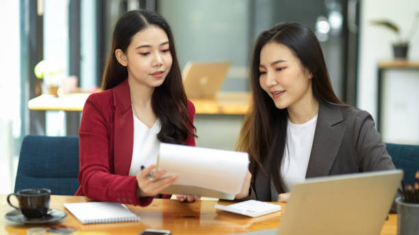 istock Two young smart business women working together on financial documents 1346102599