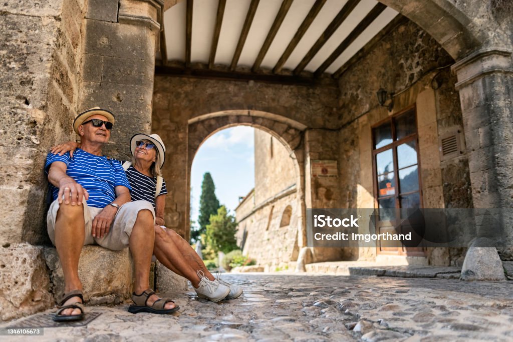 Senior couple sightseeing beautiful town of Valldemossa, Majorca, Spain Senior couple sightseeing beautiful town of Valldemossa. Sunny summer day in Majorca, Spain.
The couple is resting in a arched passage.
Canon R5 Senior Adult Stock Photo