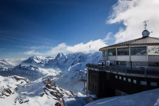 Beautiful alpine panorama on a sunny day from the top of Schilthorn, Switzerland, peak above Murren. Gorgeous landscape in switzerland with restaurant on the top