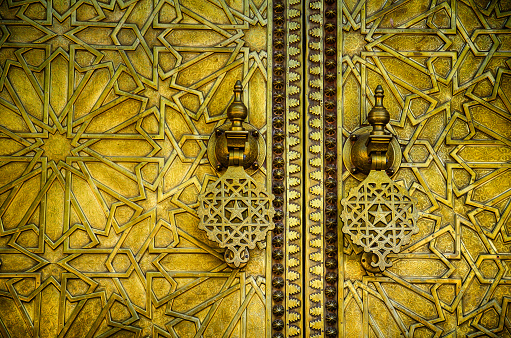 Background of traditional golden painted door with gold doorknocker